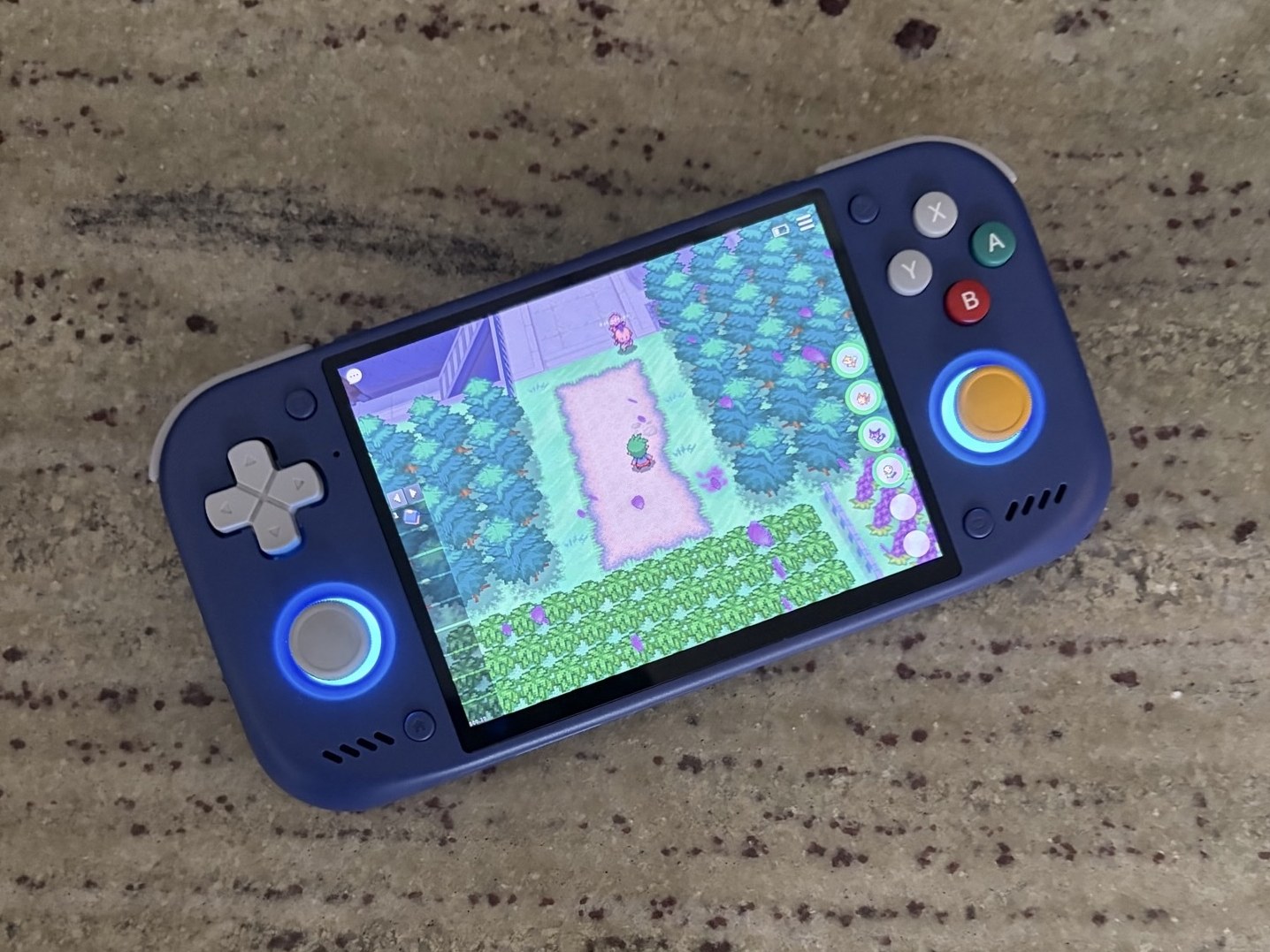 Retroid Pocket Nova, GameCube colored, laying in the table running Crystal in Gen1Recomp with Voxel Mod.